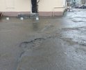 Въезд во двор домов 22 и 18/20 с ул.Октябрьской, дорожное полотно изношено, дорога неровная, большое количество ям и выбоин