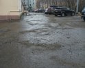 Въезд во двор домов 22 и 18/20 с ул.Октябрьской, дорожное полотно изношено, дорога неровная, большое количество ям и выбоин