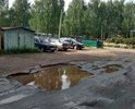 Провалы в дорожном покрытии. Автомобили объезжают ямы по газонам.